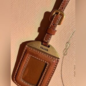 Authentic Prada luggage tag camel or café brown. gently loved gold hardware.